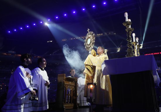 Bishop Andrew Cozzens of Crookston, Minn., chairman of the board of the National Eucharistic Congress, Inc., blesses pilgrims during adoration at the opening revival night of the 10th National Eucharistic Congress at Lucas Oil Stadium in Indianapolis July 17, 2024. 