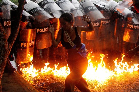 A demonstrator reacts when Molotov cocktails hit the ground in front of security forces during protests in Puerto La Cruz, Venezuela, July 29, 2024, against election results after President Nicolas Maduro and his opposition rival Edmundo Gonzalez BOTH claimed victory in the July 28 presidential election.