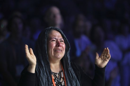 A pilgrim becomes emotional during Eucharistic adoration at the opening revival night July 17, 2024, of the National Eucharistic Congress at Lucas Oil Stadium in Indianapolis.