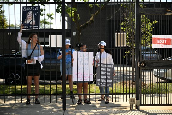 Pro-life protesters hold placards outside of a Planned Parenthood mobile clinic nearby the United Center, the host venue of the Democratic National Convention in Chicago Aug. 19, 2024. 
