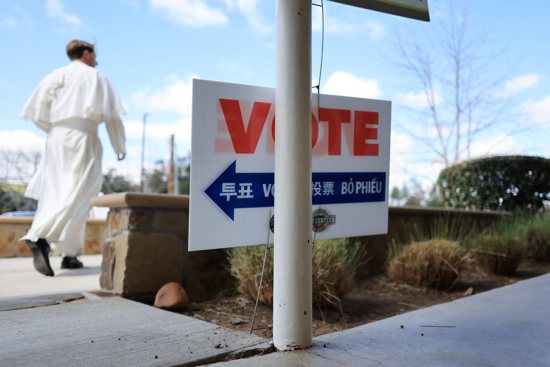 A member of the clergy walks outside a voting station at the Library of the Canyons in Silverado, Calif., during the Super Tuesday primary election March 5, 2024. 