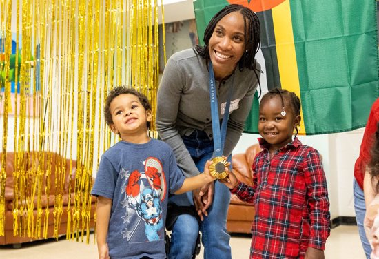 Thea LaFond-Gadson, who won a gold medal in the women's triple jump competition at the Summer Olympics in Paris, visits young residents at St. Ann's Center for Children, Youth and Families in Hyattsville, Md., during a pizza party Sept. 10, 2024.