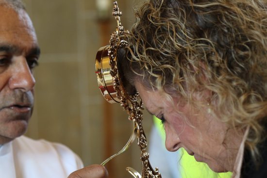 Msgr. Anthony Figueiredo, director of international affairs of the Diocese of Assisi, Italy, blesses pilgrim Natalie Orefice with a relic of the heart of Blessed Carlo Acutis during public veneration Sept. 21, 2024, at St. Anthony's Church in Manchester, England. The relic of Blessed Carlo, who will be canonized in 2025, attracted more than 5,000 pilgrims during a Sept. 20-23 visit.