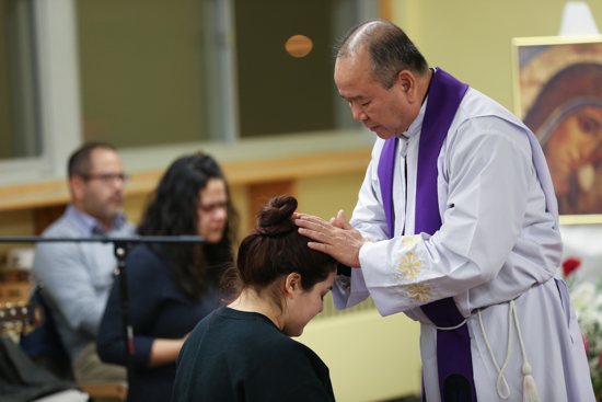 In this file photo from 2019, Father Saw Joseph Kureh offers blessing to a World Youth Day participant at St. Bernard in St. Paul.