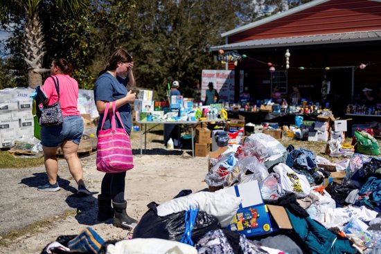 Maddie Hackney, who lost everything to the hurricane, pauses while looking for clothing Sept. 29, 2024, at a donation center in Steinhatchee, Fla., organized by Janalea and Garrett England at their business Steinhatchee Fish Co. in the wake of Hurricane Helene.