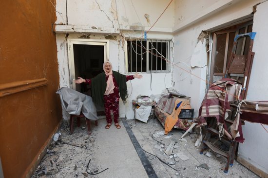 An elderly woman gestures as she stands at her damaged home in Tyre, southern Lebanon, Nov. 30, 2024, after a ceasefire between Israel and Hezbollah took effect the morning of Nov. 27. 