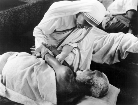 St. Teresa of Kolkata gives comfort to a sick man at the Missionaries of Charity home in Kolkata, India, in this undated photo. 