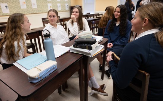 From left, ninth graders Alexis Larson, Elizabeth Fahnlander and Samantha McElroy, senior Rachel Bartels and sophomore Evelyn Mirau talk during a house meeting Jan. 14 at Providence Academy in Plymouth. Bartels is the house captain.