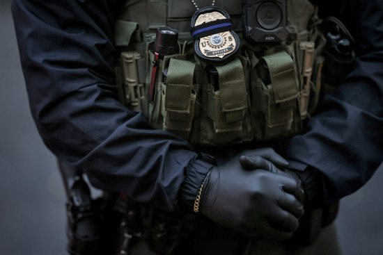 An officer from U.S. Immigration and Customs Enforcement stands next to his vehicle in Laurel, Md., Feb. 6, 2025. A federal judge in Maryland has issued a temporary order preventing immigration enforcement operations at 1,700 places of worship in 35 states, but stopped short of a nationwide injunction.