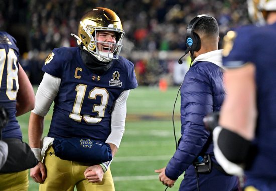 Notre Dame Fighting Irish quarterback Riley Leonard celebrates with head coach Marcus Freeman after scoring a touchdown during the second half against the Indiana Hoosiers at Notre Dame Stadium Dec. 20, 2024, in Notre Dame, Indiana.