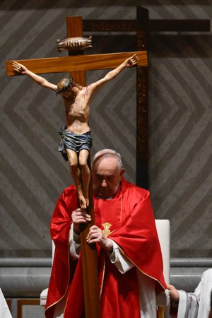 Pope Francis holds the crucifix during the Good Friday Liturgy of the Lord's Passion in St. Peter's Basilica at the Vatican March 29, 2024.
