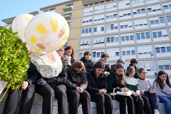 Young people and members of the House of Mary, groups associated with the Pontifical Academy of the Immaculate Conception, pray around a statue of St. John Paul II outside Rome’s Gemelli hospital March 2, 2025. Pope Francis is receiving treatment there for double pneumonia.