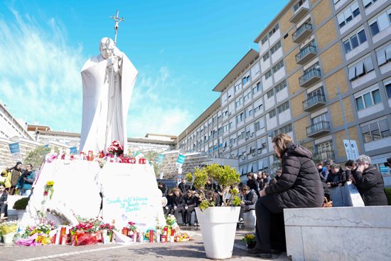 Young people and members of the House of Mary, groups associated with the Pontifical Academy of the Immaculate Conception, and others pray around a statue of St. John Paul II outside Rome’s Gemelli hospital March 2, 2025. Pope Francis is receiving treatment there for double pneumonia.