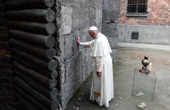 Pope Francis touches the death wall at the Auschwitz Nazi death camp in Oswiecim, Poland, in this July 29, 2016, file photo. The pope said remembering the Holocaust and its victims is not only an "expression of humanity" but also makes people aware that such horrors may happen again. The pope's comments came at his general audience as he commemorated International Holocaust Remembrance Day Jan. 27.