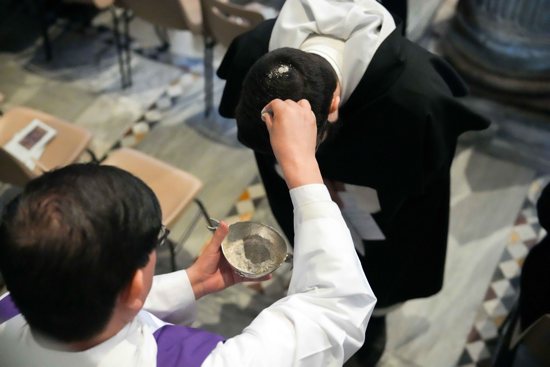 A priest distributes ashes during Ash Wednesday Mass at the Basilica of Santa Sabina in Rome March 5, 2025.