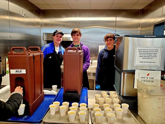 Ryan Gansler, right, helps serve breakfast with his brother, Andrew, center, and their father, Bob, Nov. 23 at Catholic Charities Twin Cities’ Dorothy Day Residence in St. Paul, as part of the Loaves and Fishes program at S. John Neumann in Eagan.