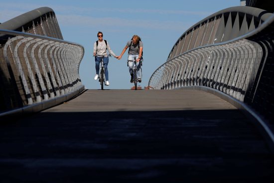 A couple holds hands while cycling in Cambridge, Mass., June 15, 2017. According to the U.S. Census Bureau, in 2023, 46.4% of American adults -- 117.6 million -- were single. That figure included those who were divorced, widowed or never married.