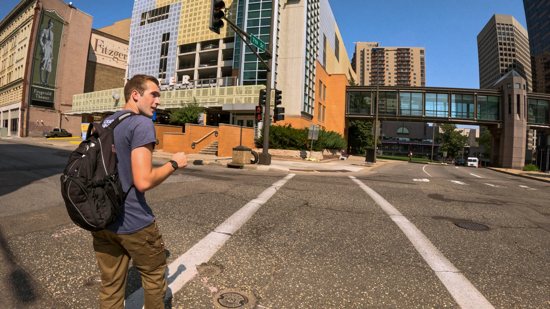 In this Sept. 11, 2024, screen grab from a video about St. John Vianney College Seminary’s (SJV) street ministry, John Paul Narog, a senior at the seminary in St. Paul, crosses a street in downtown St. Paul. 