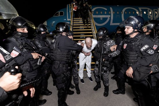 Salvadoran police officers escort an alleged member of the Venezuelan gang Tren de Aragua in Tecoluca, El Salvador, March 16, 2025, who were recently deported by the U.S. government to be imprisoned in the Terrorism Confinement Center (CECOT) prison, as part of an agreement with the Salvadoran government.