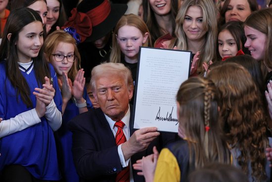 U.S. President Donald Trump holds up a signed executive order banning people who identify as transgender from participating in women's sports, in the East Room at the White House in Washington Feb. 5, 2025.