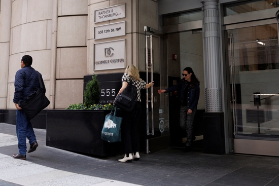 People walk with carts at the U.S. Agency for International Development in Washington March 28, 2025, where employees were being told they could go home. The Trump administration moved March 28 to formally close USAID and fold its remaining functions into the State Department.