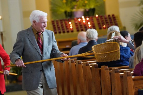 An usher uses a collection basket during the offertory portion of the Mass in this file photo from April 16, 2023. In the United States, groups of Catholic faithful are specifically committed to erasing American medical debt through a nonprofit called Undue Medical Debt. Founded by former debt collectors, the organization uses donations to buy large medical debts at a discount.