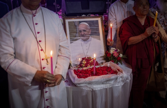 People hold candles in front of a picture of Pope Francis in New Delhi, India, April 21, 2025, after his death was announced by the Vatican. Pope Francis, formerly Argentine Cardinal Jorge Mario Bergoglio, died April 21 at age 88.