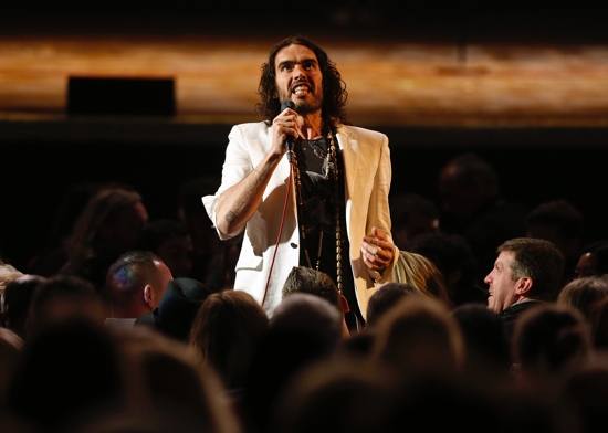 British comedian Russell Brand is pictured in a file photo performing at his Messiah Complex show at Brixton Academy in London. British police on April 4, 2024, charged Brand with rape and sexual assault following an 18-month investigation sparked when four women alleged they had been assaulted by the controversial comedian.