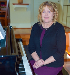 Kimberly Hess, an organist at Arlington National Cemetery in Virginia, poses for a photo in October 2024 in Sacred Heart of Mary Chapel at Marymount University in Arlington. 