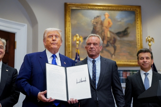 U.S. President Donald Trump holds an executive order on prescription drug pricing next to U.S. Health and Human Services Secretary Robert F. Kennedy, Jr., during a news conference in the Roosevelt Room at the White House in Washington May 12, 2025.