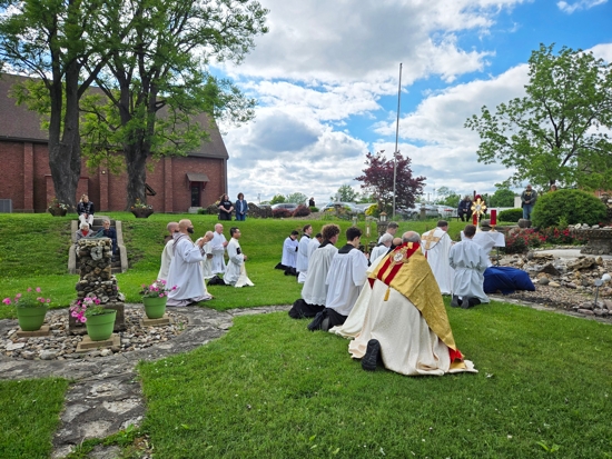 Bishop Dennis G. Walsh of Davenport, Iowa, kneels during Benediction at the grotto outside Sts. Mary and Patrick Parish in West Burlington, Iowa, May 21, 2025, as part of this year's National Eucharistic Pilgrimage.
