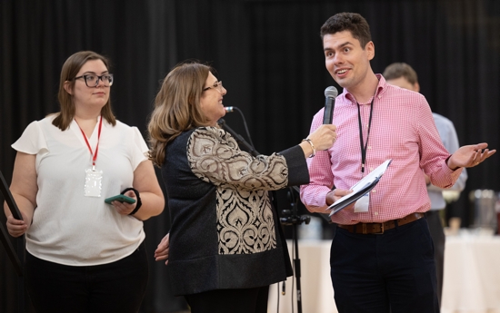 Tom Florczak, right, a synod member, offers comments during a large group session during the afternoon session of the 2025 Synod assembly June 7 at Cretin-Derham Hall high school in St. Paul. Holding the microphone is Estela Villagrán Manancero, director of Latino ministry for the Archdiocese of St. Paul and Minneapolis.
