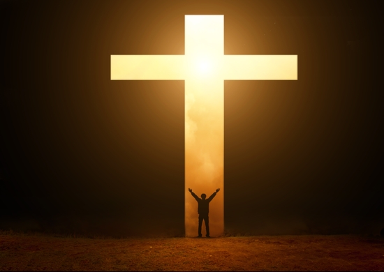 Priest, small, in front of an illuminated cross