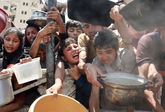 Palestinians gather to receive food from a charity kitchen amid a hunger crisis in the central Gaza Strip July 29, 2025. Despite daunting odds, Catholic Relief Services and its on-the-ground partners have managed to deliver aid to 1.7 million people in Gaza since 2023, according to new data.
