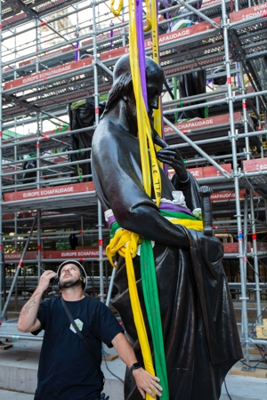 A worker looks on June 23, 2025, as a statue of St. Paul, the first of the 16 now-renovated statues that adorn the roof of Notre Dame Cathedral in Paris, is lifted by a crane, marking the last phase of reconstruction of the cathedral's roof, damaged by the April 2019 fire.