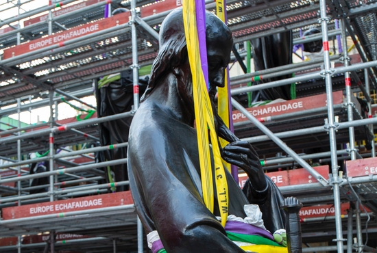 A worker looks on June 23, 2025, as a statue of St. Paul, the first of the 16 now-renovated statues that adorn the roof of Notre Dame Cathedral in Paris, is lifted by a crane, marking the last phase of reconstruction of the cathedral's roof, damaged by the April 2019 fire.