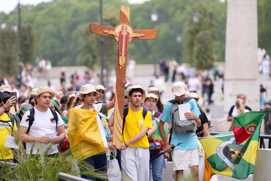 Young pilgrims carry a cross as they walk toward the Vatican during a pilgrimage in Rome, July 28, 2025.