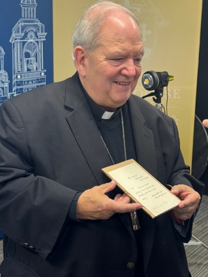 Archbishop Bernard Hebda holds a letter written by St. John Henry Newman that recently came into his possession. The Vatican announced July 31 that Pope Leo XIV will name the saint a doctor of the Church. 