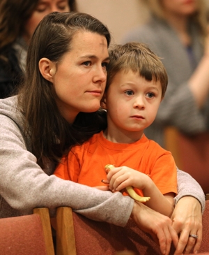 A file photo shows a mother and son listening to the homily during Ash Wednesday Mass in the chapel at the Franciscan Monastery of the Holy Land in Washington.