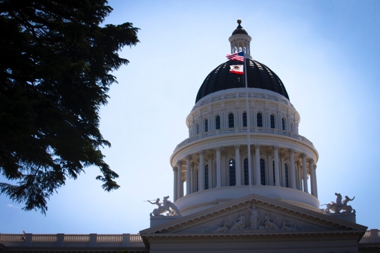U.S. and California flags fly in front of the dome of the California Capitol in Sacramento May 9, 2019. Catholics have lauded Gov. Gavin Newsom's July 30 signing of a state law that makes it a felony to procure sex from a 16- or 17-year-old minor in the state of California. 
