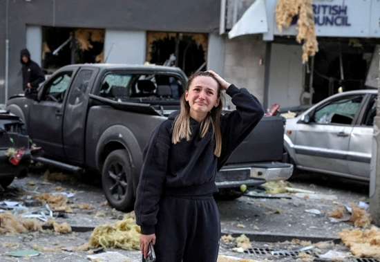 A woman reacts near a building housing the local branch of the British Council, as she stands at the site of an apartment building hit during Russian missile and drone strikes in Kyiv, Aug. 28, 2025.