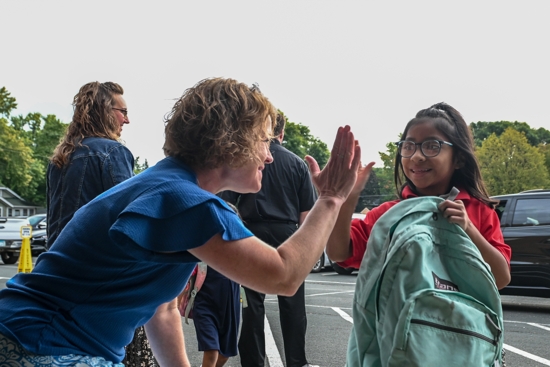 Heidi Gallus, principal of St. Michael Catholic School in St. Michael, high fives first grader Keily Aschenbeck as she walks into school on the first day of the 2025-2026 school year. The school is marking its 150th year of serving the community of St. Michael, a community located northwest of the Twin Cities.