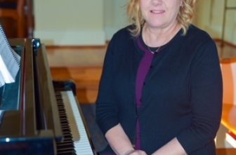 Kimberly Hess, an organist at Arlington National Cemetery in Virginia, poses for a photo in October 2024 in Sacred Heart of Mary Chapel at Marymount University in Arlington.