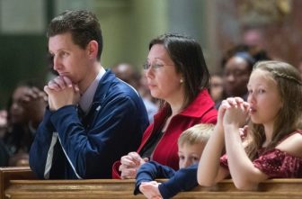 A file photo shows a family praying during Mass at the Cathedral of St. Matthew the Apostle in Washington.