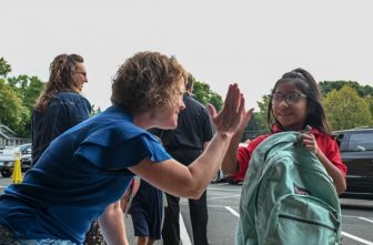 Heidi Gallus, principal of St. Michael Catholic School in St. Michael, high fives first grader Keily Aschenbeck as she walks into school on the first day of the 2025-2026 school year. The school is marking its 150th year of serving the community of St. Michael, a community located northwest of the Twin Cities.