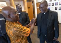 Father John Mbua Mwandi of the Diocese of Kitui, Kenya, right, greets George Mutua, left, May 11 at St. Gerard Majella in Brooklyn Park following a Mass to celebrate the 20th anniversary of a partnership between the Archdiocese of St. Paul and Minneapolis and the Diocese of Kitui. Another member of the delegation from Kitui was Father George Marete, center.
