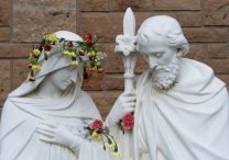 Flowers fill bullet holes on a Holy Family statue outside Annunciation Church in Minneapolis Sept. 2, 2025, which was the scene of a shooting Aug. 27. The shooter opened fire with a rifle through the windows of the church and struck children from the parish school who were attending Mass during the first week of school, killing two and wounding 21 others.