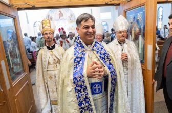 Father George Younes, center, exits the sanctuary at the end of his priest ordination liturgy at St. Maron in Minneapolis July 26. At left is Chorbishop Don Sawyer of Austin, Texas, and at right is Chorbishop Sharbel Maroun, pastor of St. Maron.  DAVE HRBACEK  | THE CATHOLIC SPIRIT