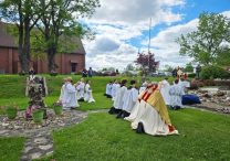 Bishop Dennis G. Walsh of Davenport, Iowa, kneels during Benediction at the grotto outside Sts. Mary and Patrick Parish in West Burlington, Iowa, May 21, 2025, as part of this year's National Eucharistic Pilgrimage.