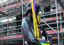 A worker looks on June 23, 2025, as a statue of St. Paul, the first of the 16 now-renovated statues that adorn the roof of Notre Dame Cathedral in Paris, is lifted by a crane, marking the last phase of reconstruction of the cathedral's roof, damaged by the April 2019 fire.